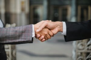 A close-up of two businesspeople shaking hands, symbolizing cooperation and partnership.